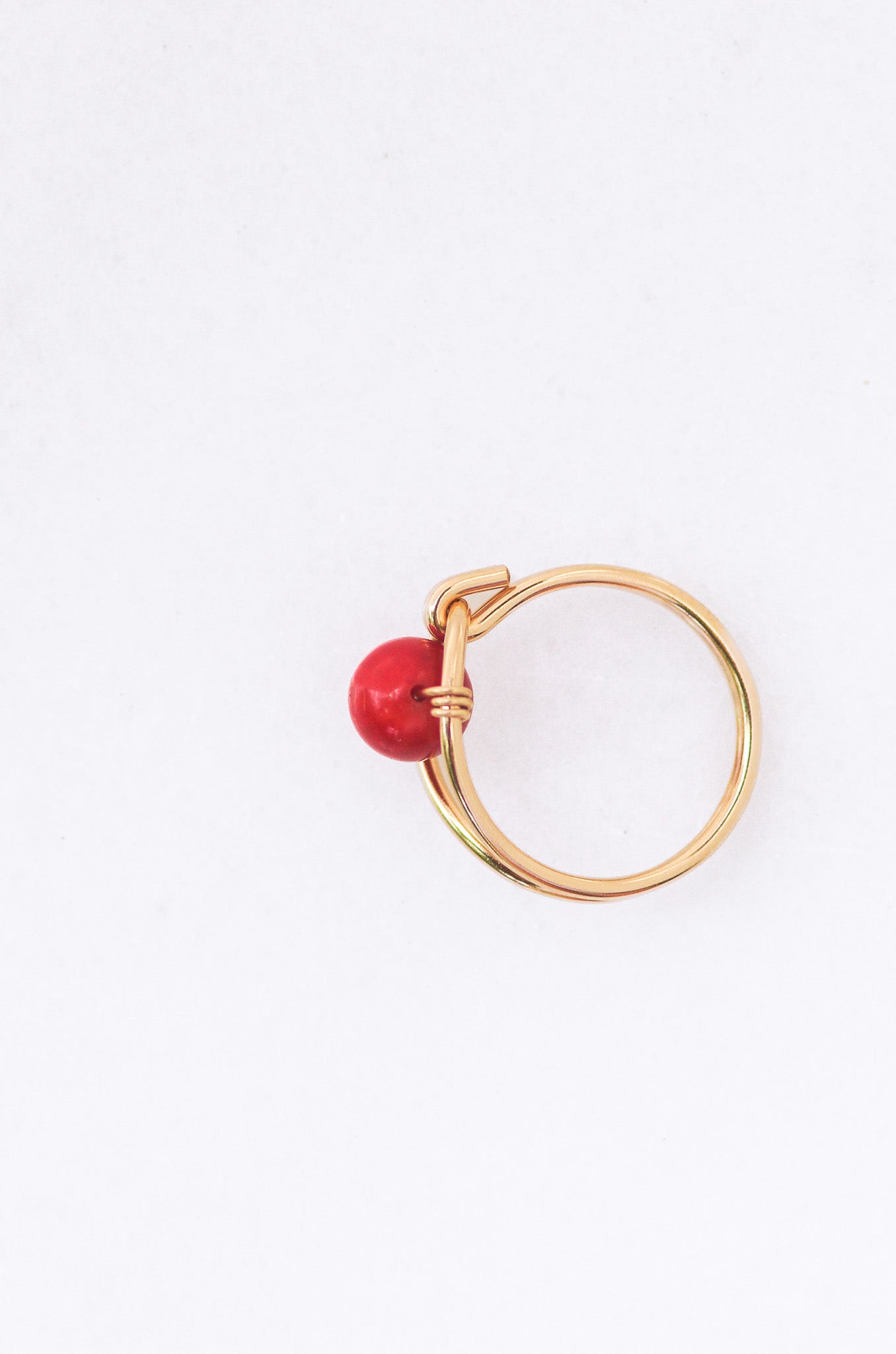 Sustainable Gold ring with a red coral on a white background