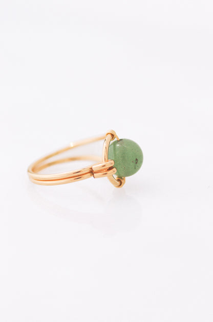 Sustainable Gold ring with a green stone on a white background