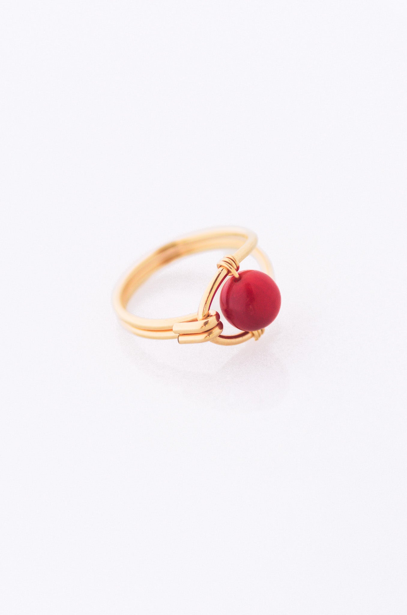 Sustainable Gold ring with a red coral on a white background
