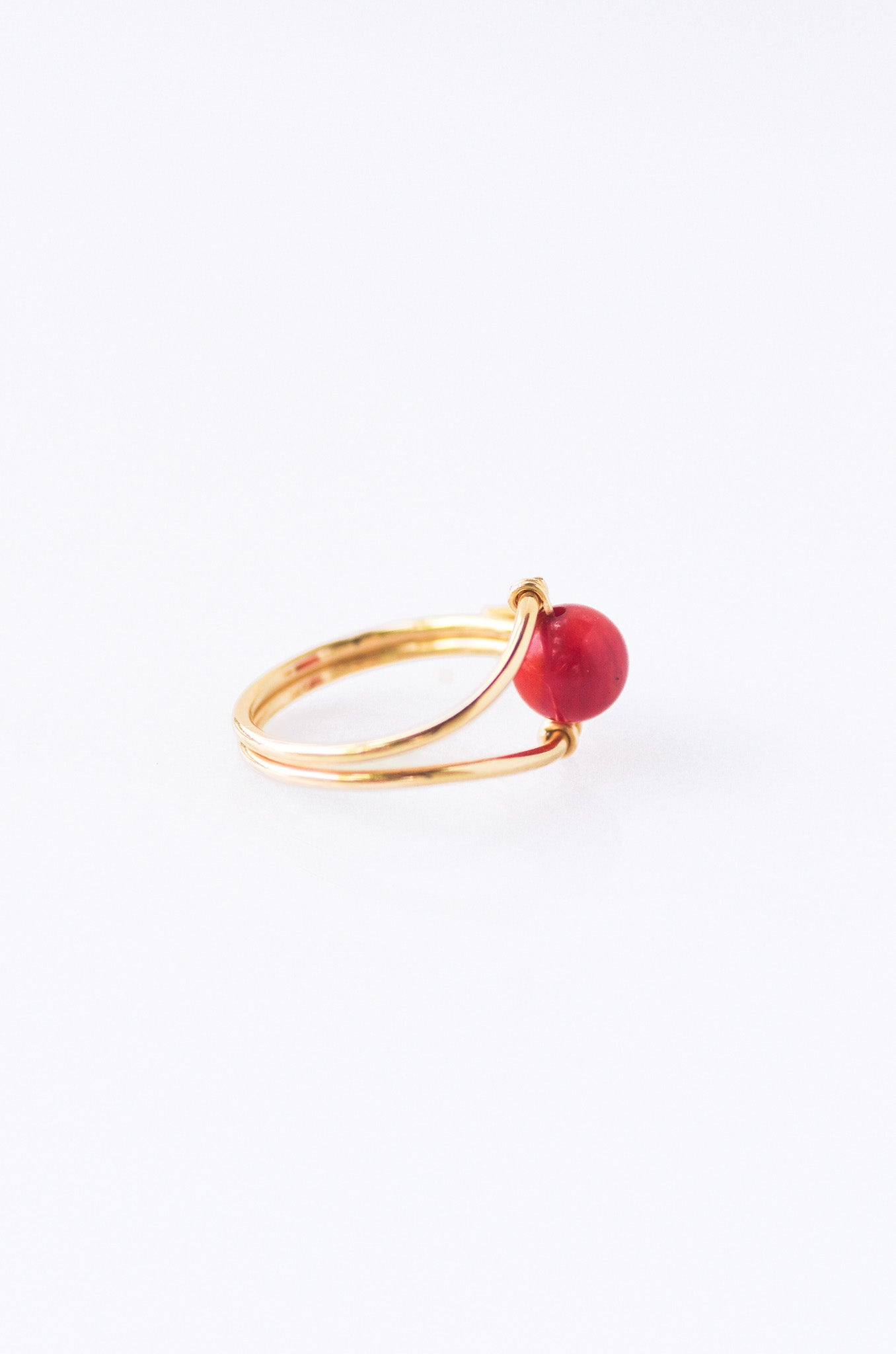 Sustainable Gold ring with a red coral on a white background