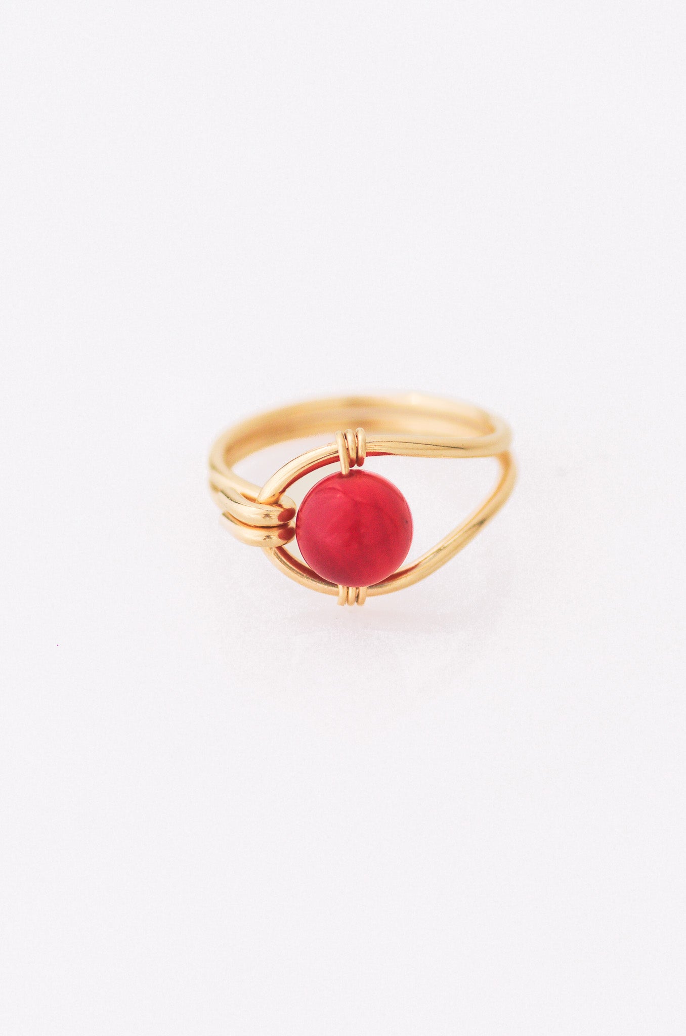 Sustainable  Gold ring with a red gemstone on a white background