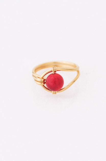 Sustainable  Gold ring with a red gemstone on a white background