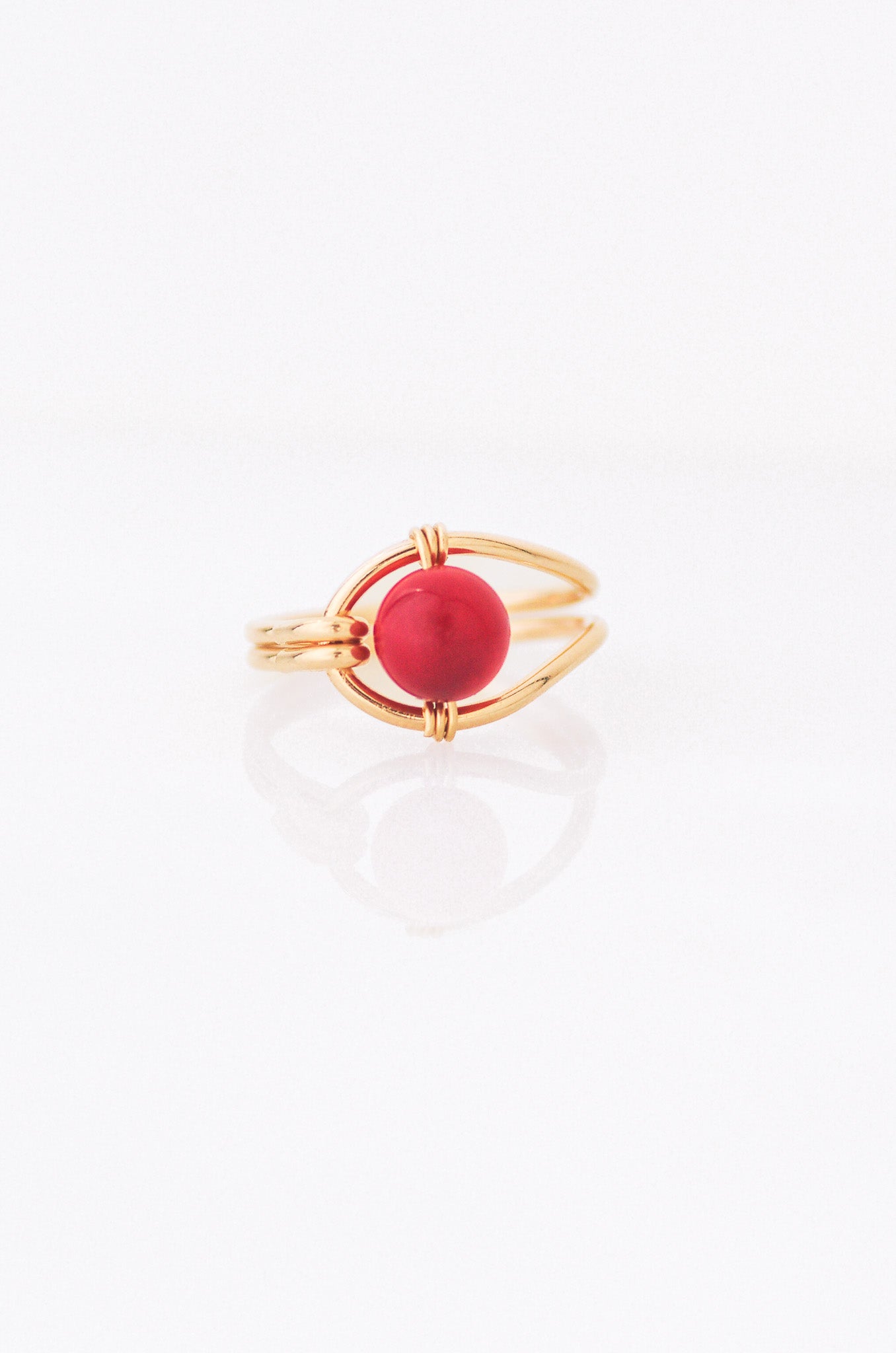 Sustainable Gold ring with a red coral on a white background